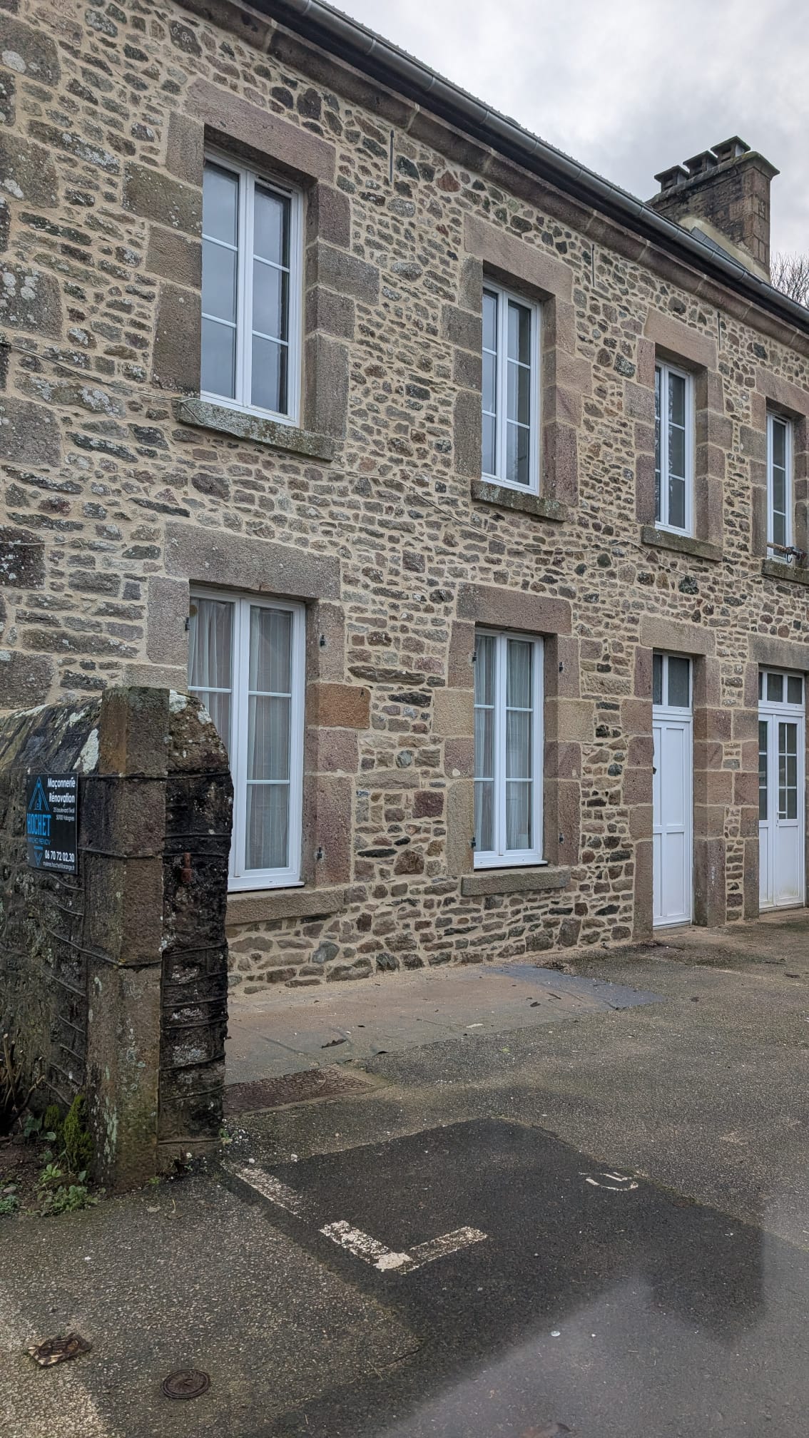 Façade en pierre rénovée par Hochet Myl'Ho Rénov, menuiseries blanches